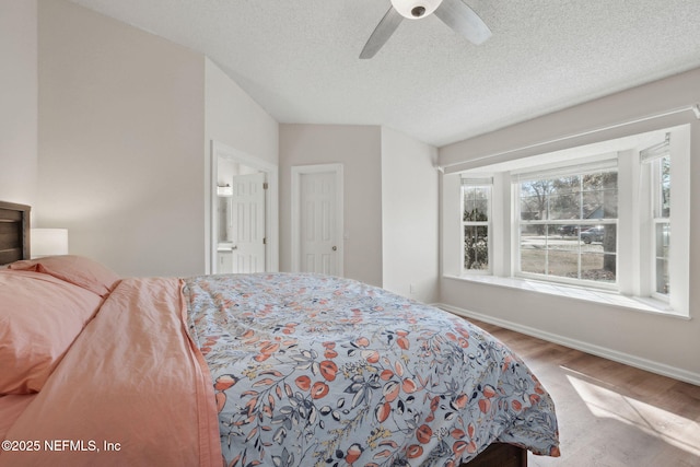 bedroom with ceiling fan, hardwood / wood-style floors, and a textured ceiling