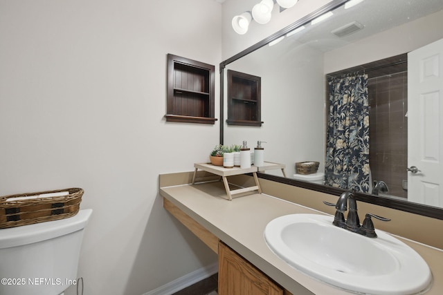 bathroom featuring toilet, vanity, and walk in shower