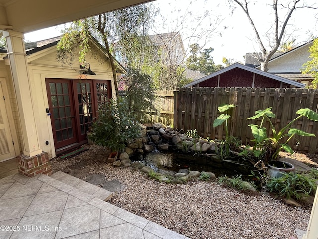 view of yard featuring a patio area, fence, and french doors