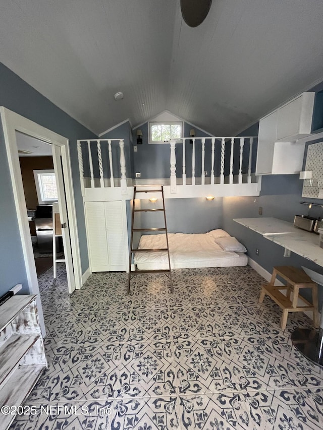 interior space with lofted ceiling and baseboards