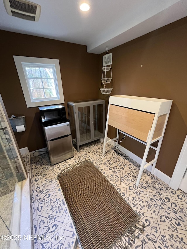 interior space with tile patterned flooring, visible vents, and baseboards