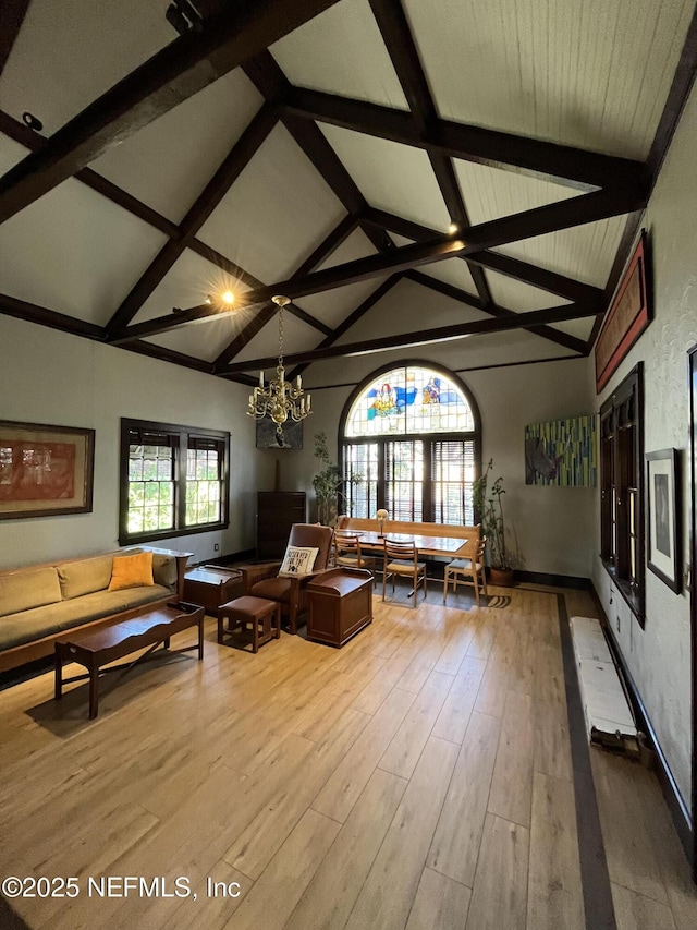 unfurnished living room with wood finished floors, a wealth of natural light, and an inviting chandelier