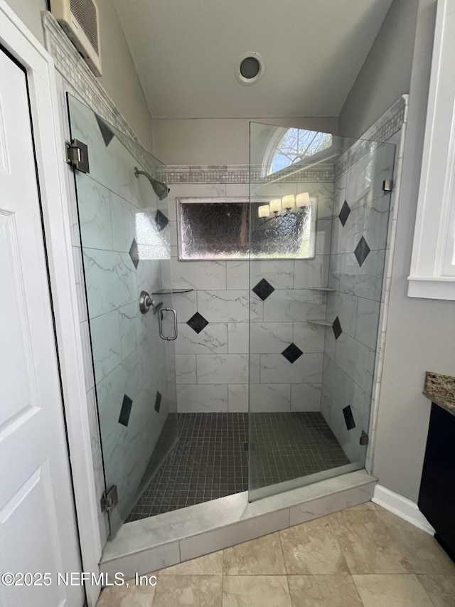 full bathroom featuring a stall shower, vanity, visible vents, and baseboards