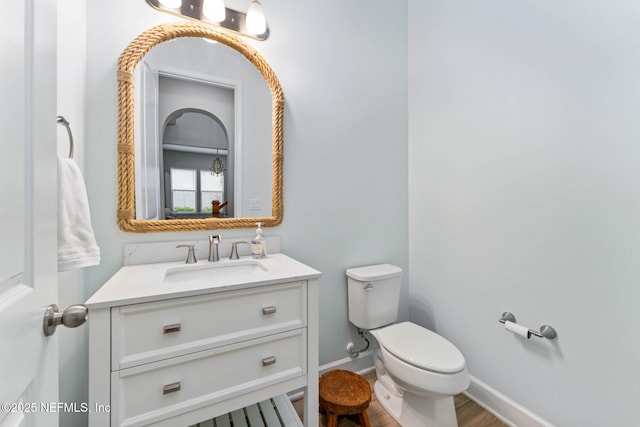 bathroom with vanity, toilet, and wood-type flooring