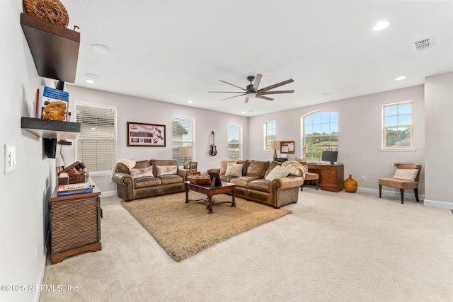 carpeted living room with ceiling fan