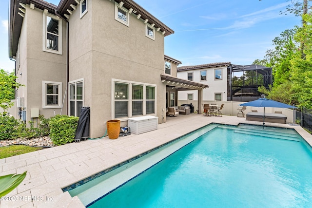 rear view of house with a pergola, outdoor lounge area, a patio, and a lanai