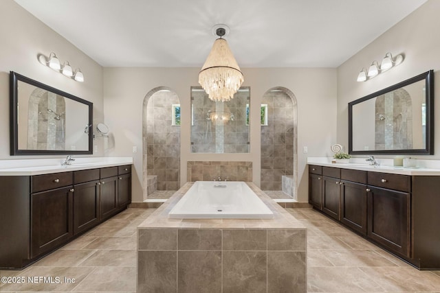 bathroom with vanity, a notable chandelier, and plus walk in shower