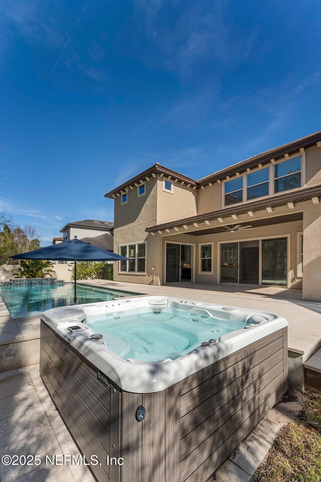 view of pool with a hot tub and a patio