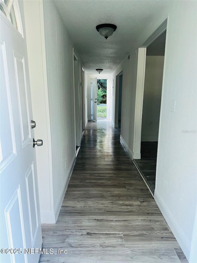 hallway featuring a textured ceiling and wood-type flooring