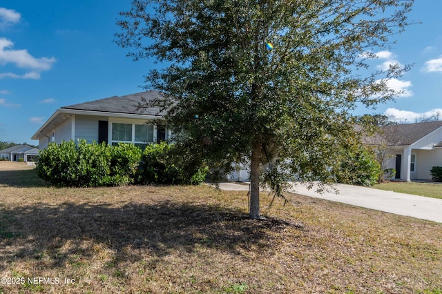 view of front of property featuring concrete driveway and a front yard