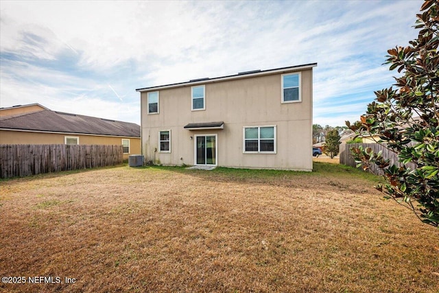 rear view of property featuring central AC unit and a lawn