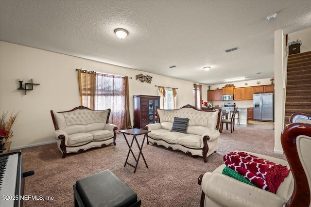 carpeted living room featuring a textured ceiling