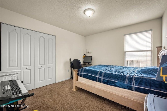 carpeted bedroom featuring a closet and a textured ceiling