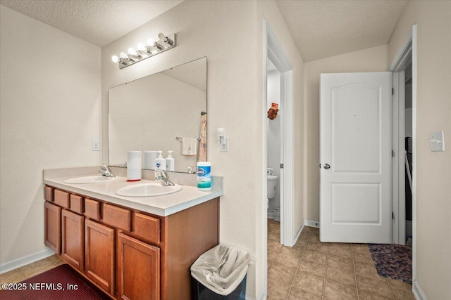 bathroom with toilet, a textured ceiling, lofted ceiling, and vanity