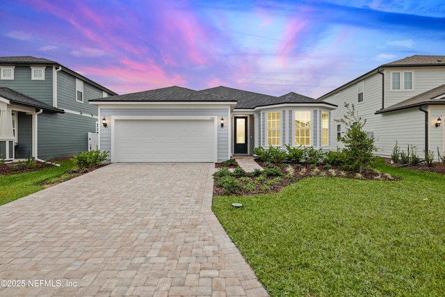 view of front of home with a garage and a yard