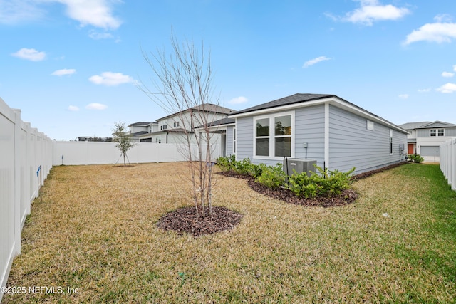 back of house with a lawn and central air condition unit