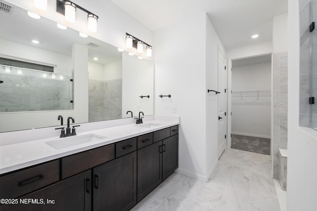 bathroom with tiled shower and vanity