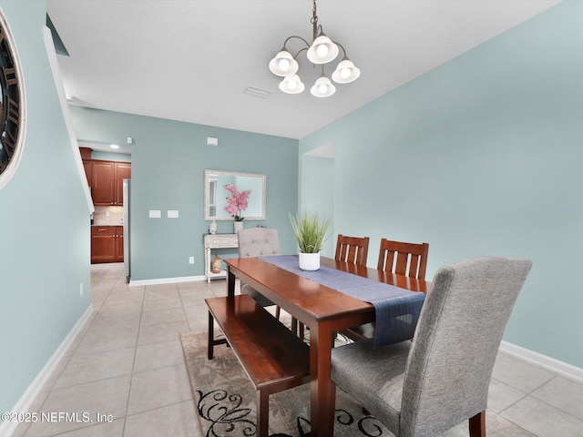 dining room with light tile patterned floors and an inviting chandelier