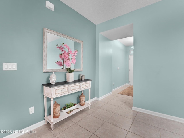 hall with light tile patterned floors and a textured ceiling