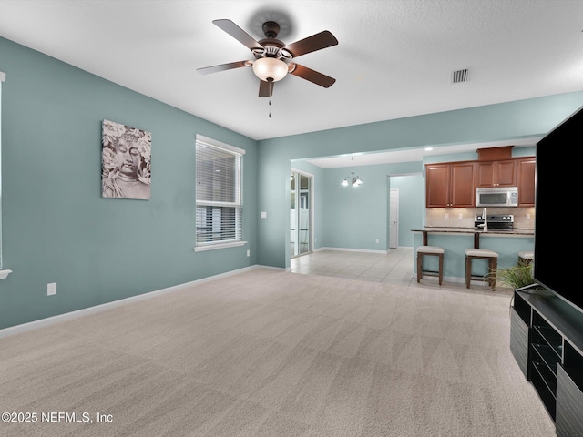 carpeted living room with ceiling fan