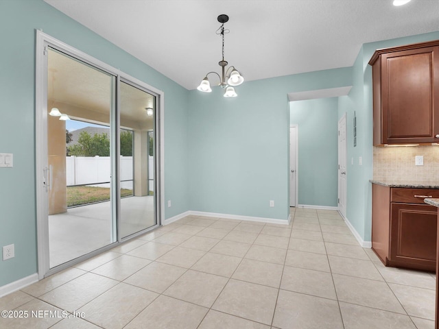 unfurnished dining area featuring light tile patterned floors and a chandelier