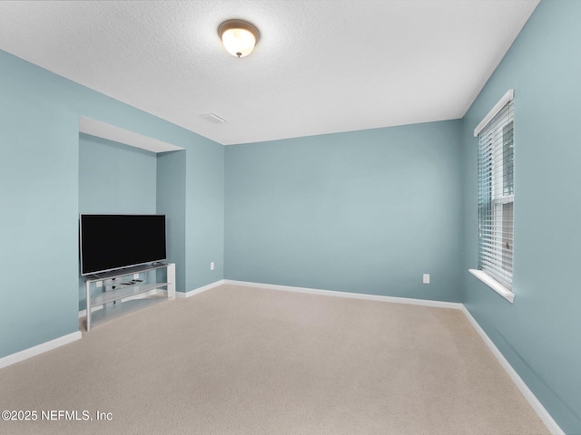 unfurnished living room featuring carpet flooring and a textured ceiling