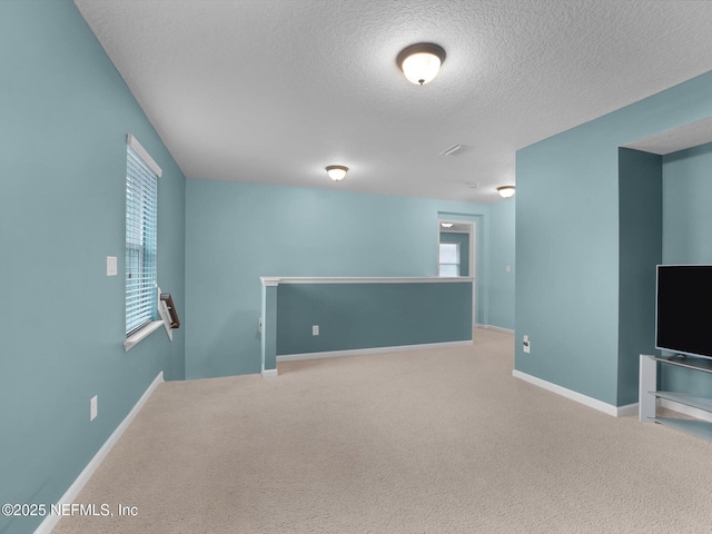 carpeted empty room with a textured ceiling