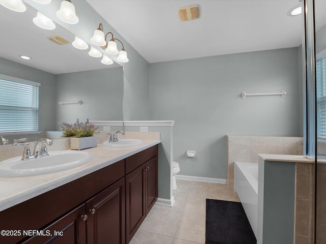 bathroom with tile patterned floors, toilet, vanity, and tiled tub