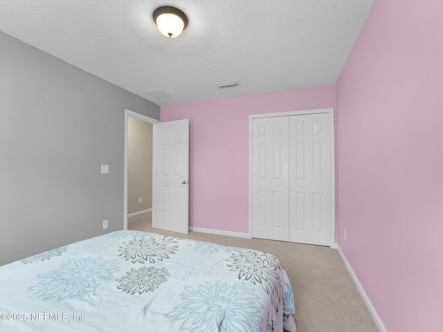 bedroom with carpet floors, a closet, and a textured ceiling