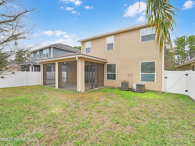 rear view of property featuring a sunroom, a yard, and central AC