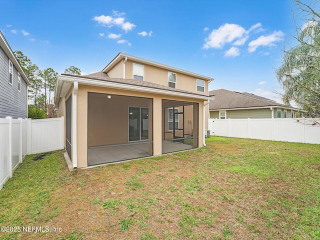 back of property with a lawn and a sunroom