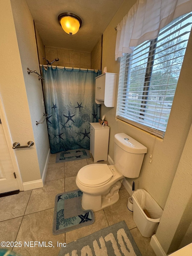 bathroom with toilet, a shower with curtain, and tile patterned floors