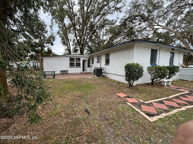 back of house featuring a yard and central air condition unit