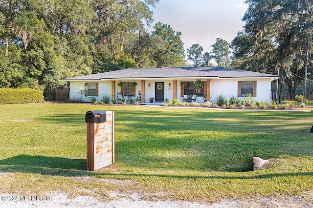 single story home featuring covered porch and a front lawn