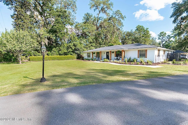 ranch-style home with a porch and a front yard