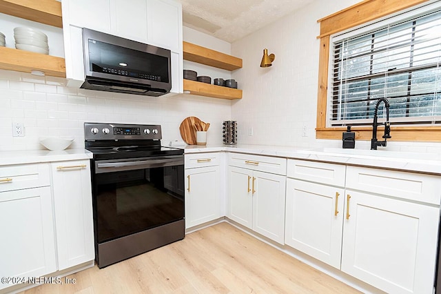 kitchen with light hardwood / wood-style floors, sink, white cabinets, and stainless steel appliances