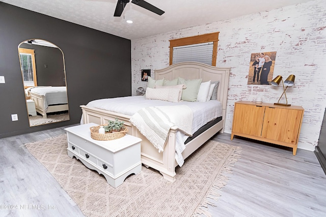 bedroom featuring ceiling fan, a textured ceiling, and light hardwood / wood-style flooring