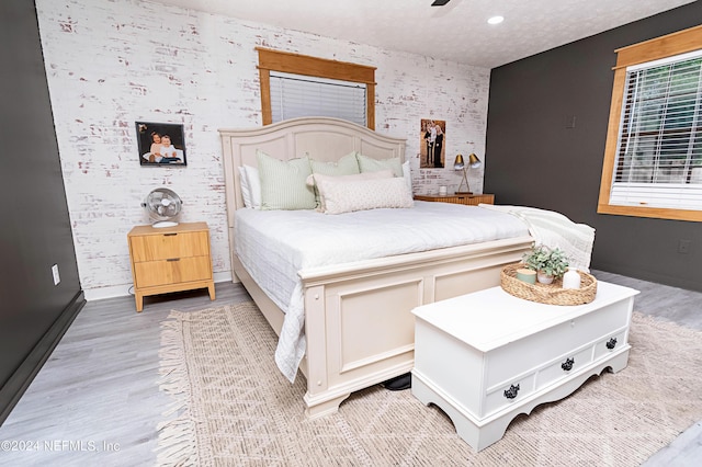 bedroom featuring a textured ceiling and light hardwood / wood-style floors