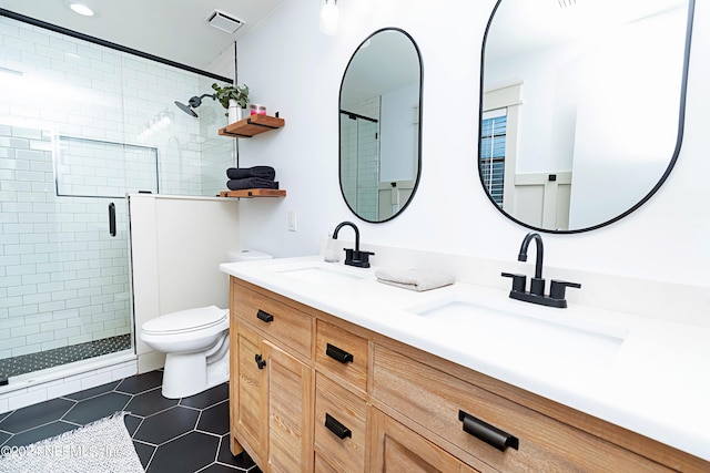 bathroom with toilet, tile patterned flooring, a shower with door, and vanity