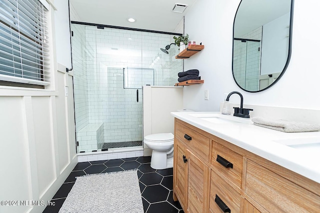 bathroom with an enclosed shower, tile patterned floors, vanity, and toilet