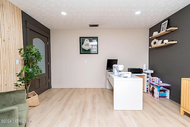 home office featuring a textured ceiling and light wood-type flooring