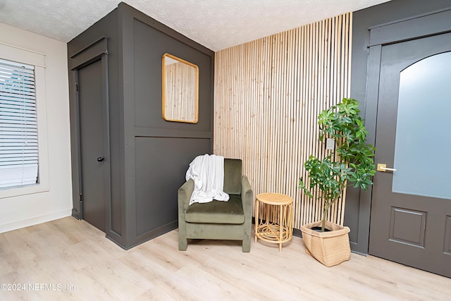 sitting room featuring a textured ceiling and light hardwood / wood-style floors