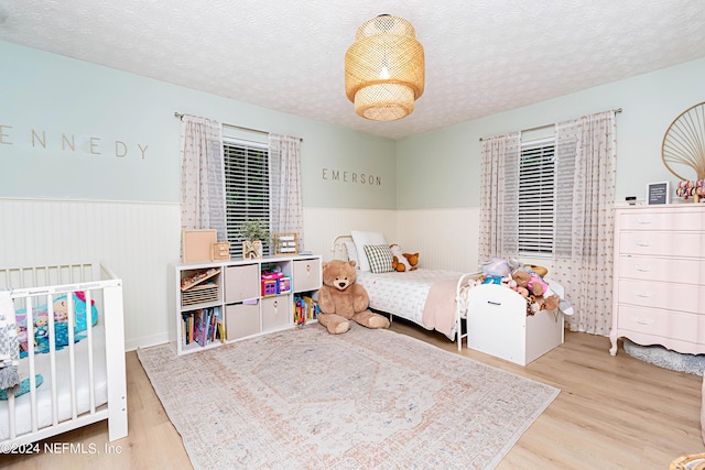 bedroom with light wood-type flooring and a textured ceiling