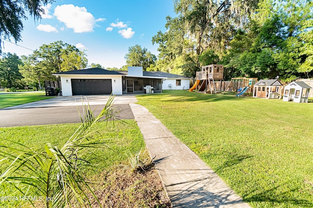 view of front of home with a playground, a front lawn, and a garage