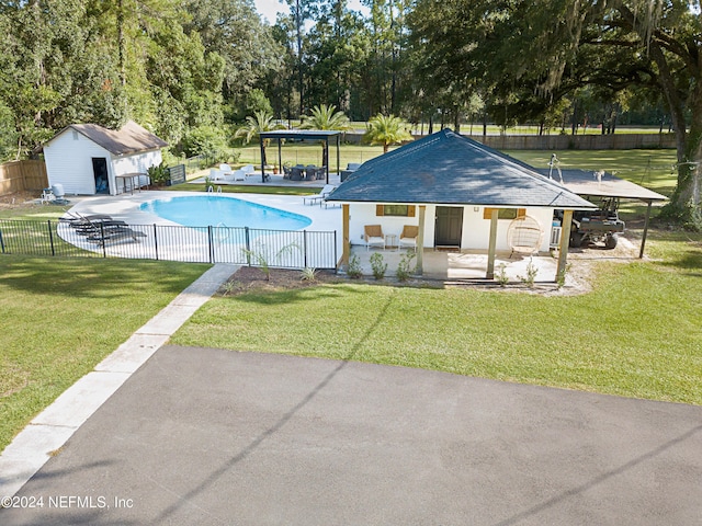 view of swimming pool with a yard, a patio, and an outdoor structure