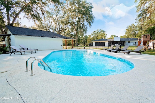 view of swimming pool featuring a playground and a patio