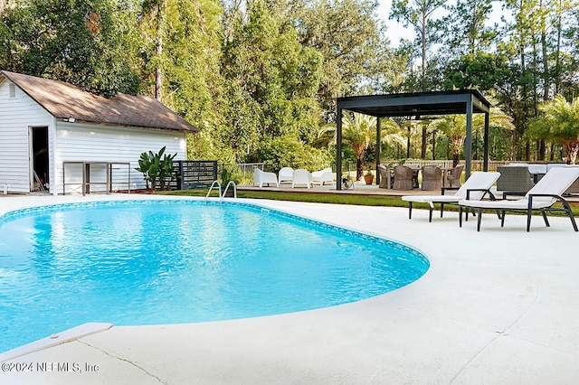 view of pool featuring a patio area and an outdoor structure