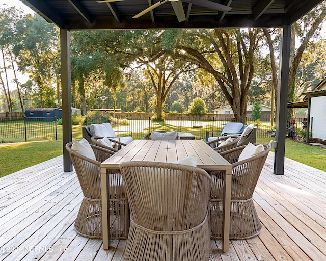 wooden deck featuring ceiling fan and a lawn