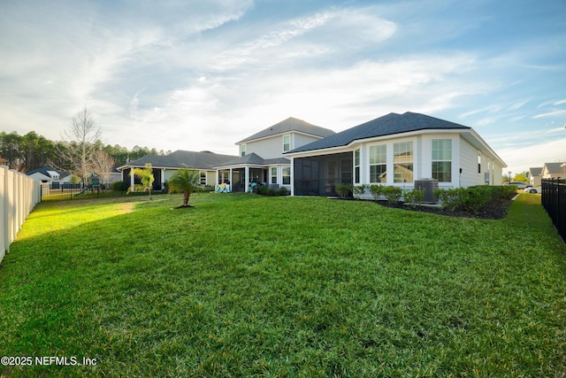 view of front of property featuring a sunroom and a front yard