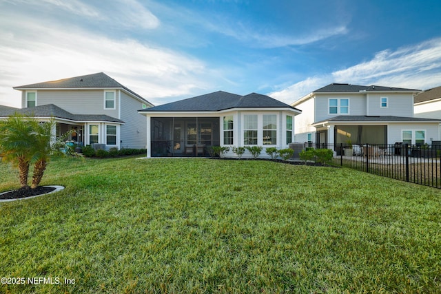 rear view of house with a lawn and a sunroom